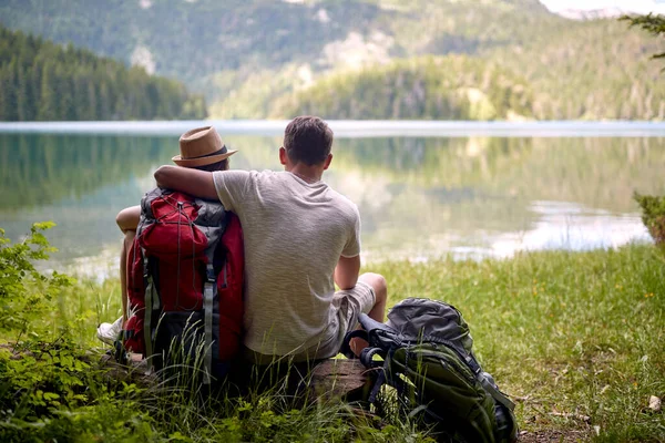 Couple Randonnée Câlin Assis Devant Lac Avec Des Sacs Dos — Photo