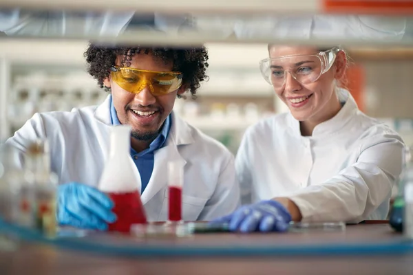 年轻的化学专业学生穿着防护服 就像在大学实验室里轻松地使用五彩缤纷的化学物质 实验室 — 图库照片