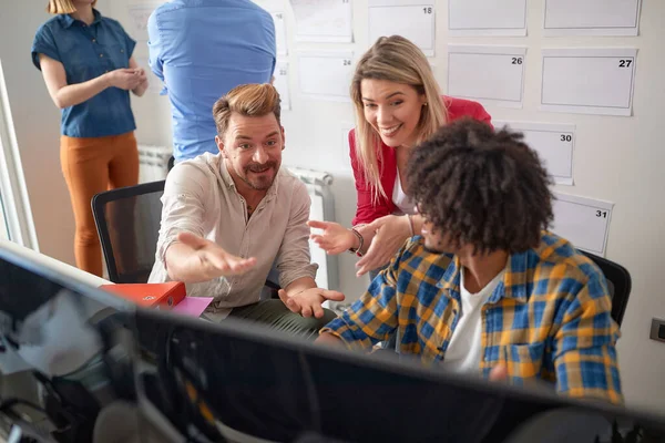 Young colleagues are chatting at work in a pleasant atmosphere in the office. Employees, job, office