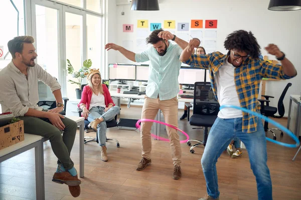 一群员工在办公室里放松的气氛中玩呼啦圈时 玩得很开心 办公室 — 图库照片