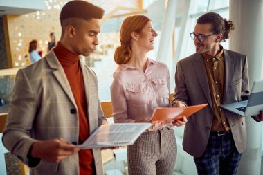 Genç iş adamları koridorda hoş bir atmosferde duruyor ve iş hakkında sohbet ediyorlar. İş, insanlar, şirket.