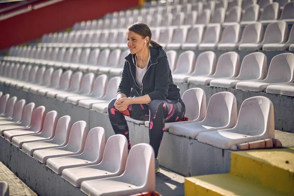 Fit Brunette Zit Alleen Tribune Bij Daglicht — Stockfoto