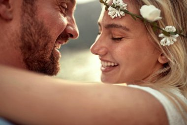 Güzel, gülümseyen kadın erkeğinin kucaklamasından zevk alır.