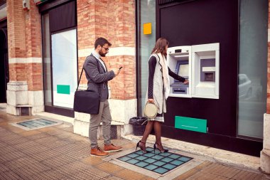 Business Woman para çekmek için ATM 'ye plastik kredi kartı taktı