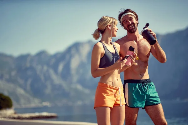 Lächelnder Mann Und Frau Trinken Nach Fitnesssport Wasser Aus Der — Stockfoto