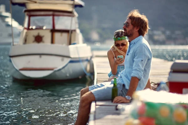 Genç çift gölün kıyısında eğleniyor. Mesaj atan kız.