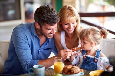 Babası küçük kızına hamur işi çubuğu veriyor.