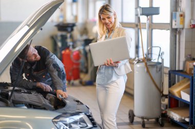 Erkek tamirci gülümseyen müşteriyle iletişim kurar