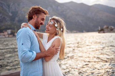 Deniz kenarında aşık yeni evli bir çift. Gelin ve damadın romantik randevusu, sarılma. Düğün, balayı, aşk konsepti