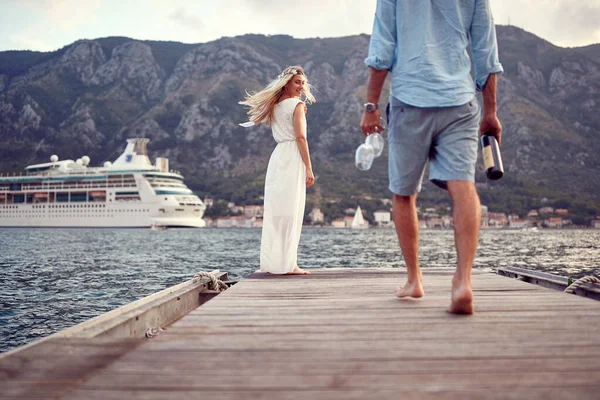 Genç bir çift, deniz kenarında güzel bir günde şarap içerken harika vakit geçiriyorlar. Aşk, ilişki, tatil, deniz