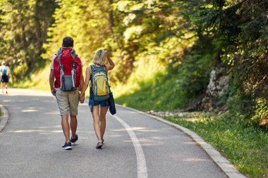  Sırt çantalarıyla yürüyen ve doğanın tadını çıkaran genç bir çift.