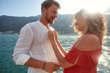 Genç bir çift, deniz kenarında güneşli bir günde körfezde yürürken harika vakit geçiriyorlar. Aşk, ilişki, tatil, deniz