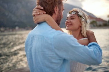 Gelin ve damat kucaklaşarak balayına çıktılar. Mutlu gelin kocaya bakıyor. Düğün, balayı, aşk konsepti