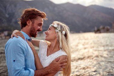 Birbirine aşık genç bir çift, deniz kenarında güzel bir günde tatil yaparken kucaklaşır. Aşk, ilişki, tatil, deniz