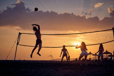 Plajda voleybol. Genç arkadaşlar plajda voleybol oynuyor.