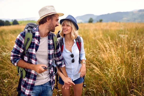 Young Couple Chatting While Walking Meadow Beautiful Sunny Day Hiking — стоковое фото