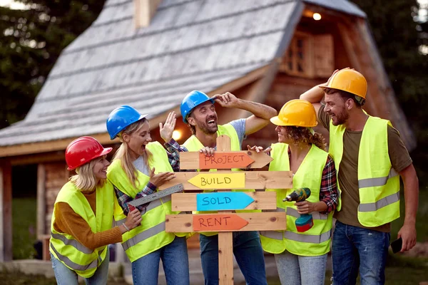 Genç inşaat işçileri bir dağ evi projesinde birlikte çalışıyorlar.