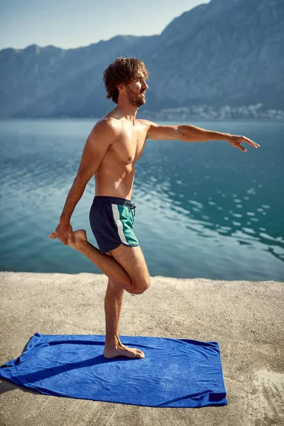 Man Doing Stretching Exercise Jetty Water Beautiful Background Sea Mountains — Stock Photo, Image