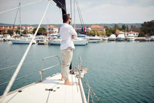 ヨットで一人で航海するカジュアルな魅力的な男 — ストック写真