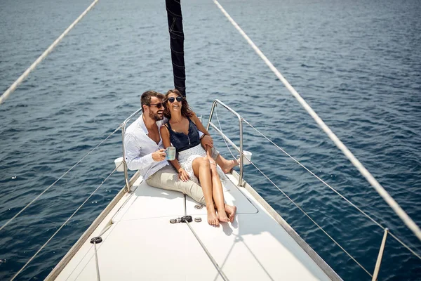 Genç bir çift yatın pruvasında oturuyor ve güzel güneşli bir denizde gezintinin tadını çıkarıyor. Yaz, deniz, tatil, ilişki