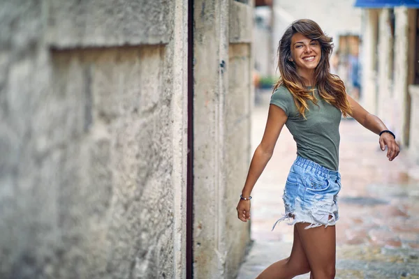 美しいブルネットが通りを歩く 普段着 美しい輝く笑顔 ライフスタイルの概念 — ストック写真