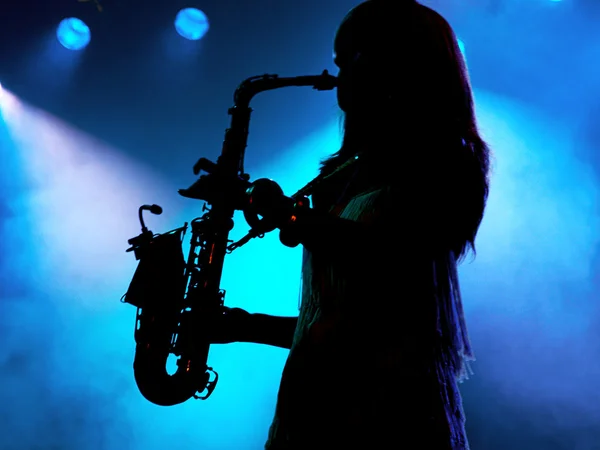 Девушка играет на саксофоне — стоковое фото