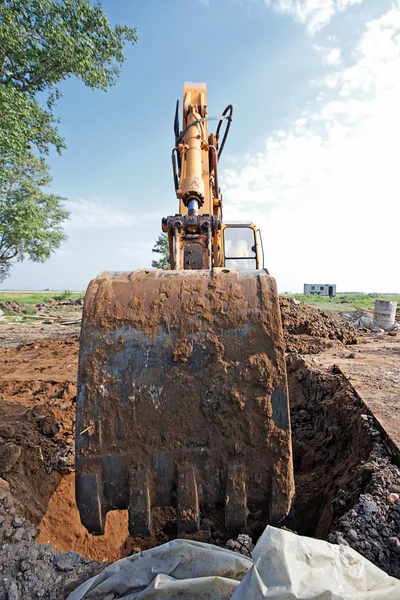 Escavadeira cava um buraco — Fotografia de Stock