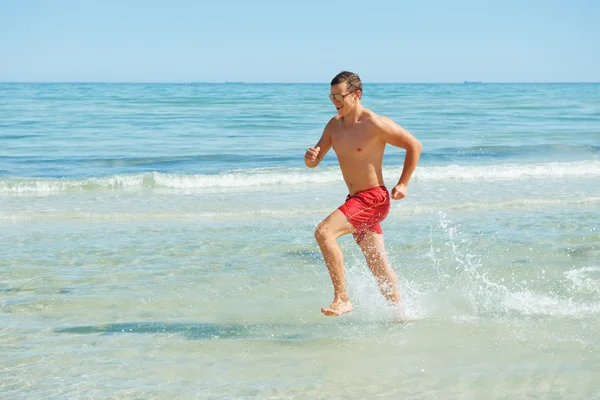 Człowiek biegnie wzdłuż wybrzeża — Zdjęcie stockowe