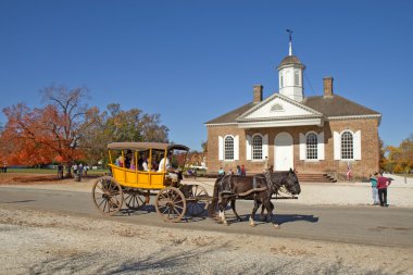 A horse-drawn carriage rides in front of the courthouse building clipart