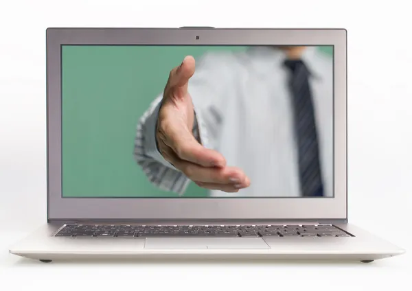 Business man hand reaching out from screen to shake — Stock Photo, Image