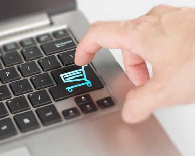Online uğraşan ve con alışveriş sepeti düğmesini alışveriş dizüstü bilgisayar itmek