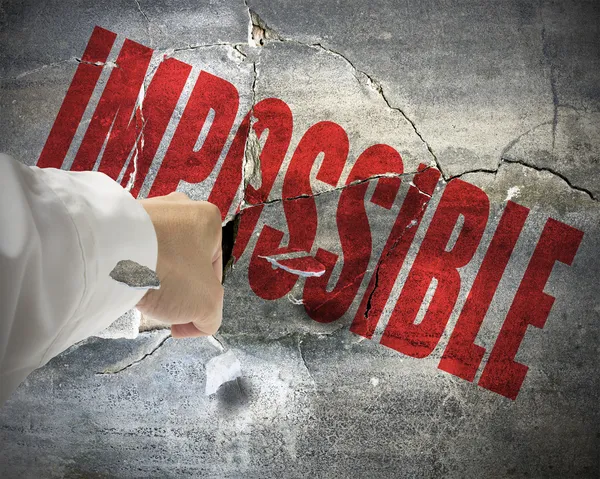 Punching, break concrete wall with word impossible on it, make i — Stock Photo, Image