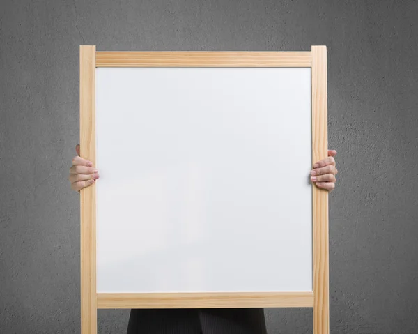 Empresário usar duas mãos para levantar madeira placa branca em branco i — Fotografia de Stock