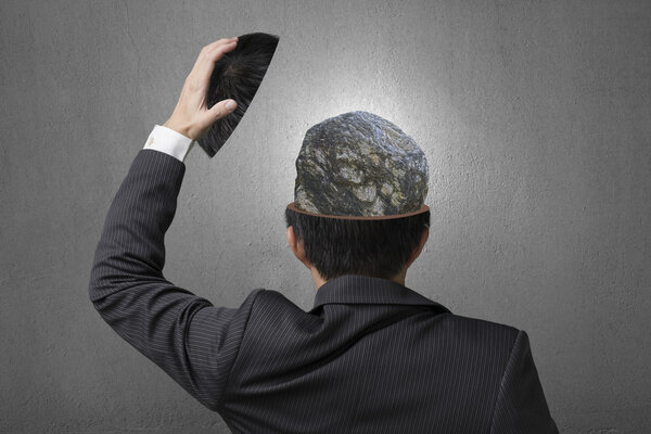 Hard stone covered with lines inside businessman head in gray co