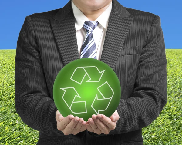 Pengusaha dua tangan memegang bola hijau dengan simbol daur ulang dengan g — Stok Foto