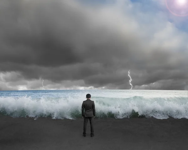 Homme d'affaires debout vers les vagues et le ciel cludy avec la foudre  , — Photo