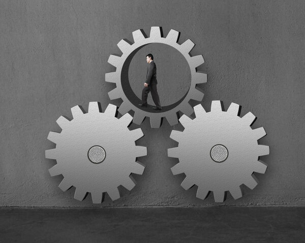 Бизнесмен, идущий внутри большой шестерни, соединяясь с другими
