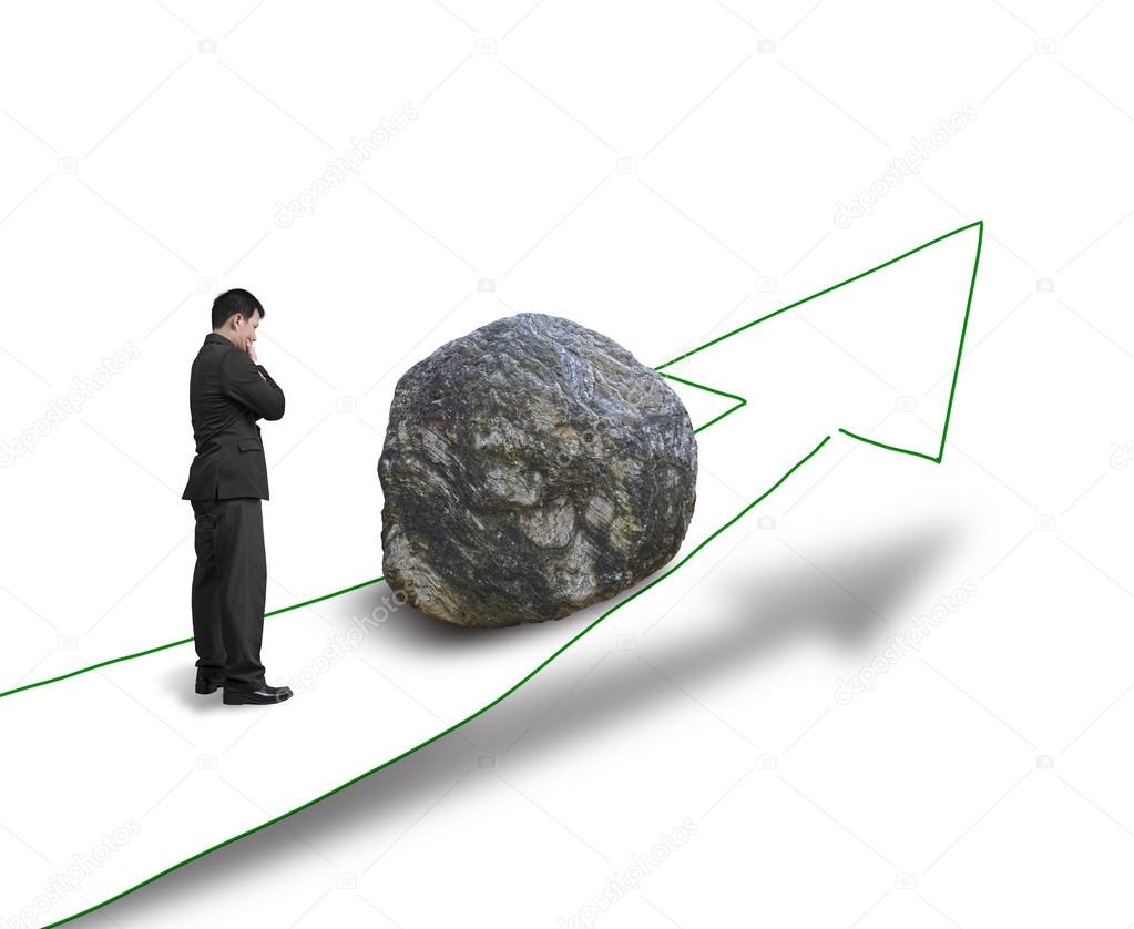 Businessman thinking and standing against large rock on the way