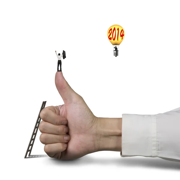 Businessman on top of thumb, another standing in balloon with 20 — Stock Photo, Image