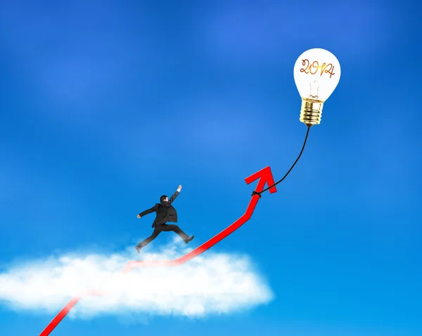 Businessman running on growth red arrow with glowing lamp balloon — Stock Photo, Image