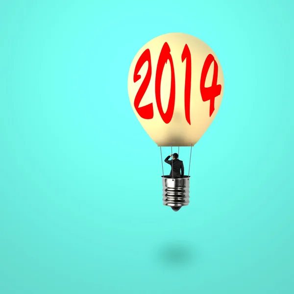 Man taking glowing lamp balloon with 2014 word on it — Stock Photo, Image