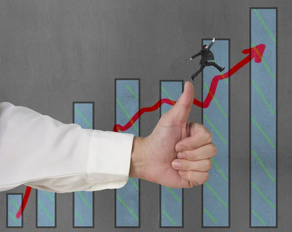 Businessman jumping on growing red arrow with thumb up — Stock Photo, Image