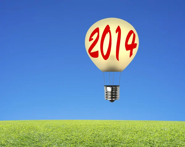 Balão de lâmpada única com 2014 voando sobre o prado, fundo do céu — Fotografia de Stock