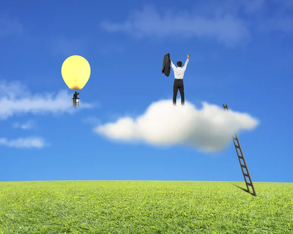 Businessman standing on cloud, another in lamp balloon — Stock Photo, Image