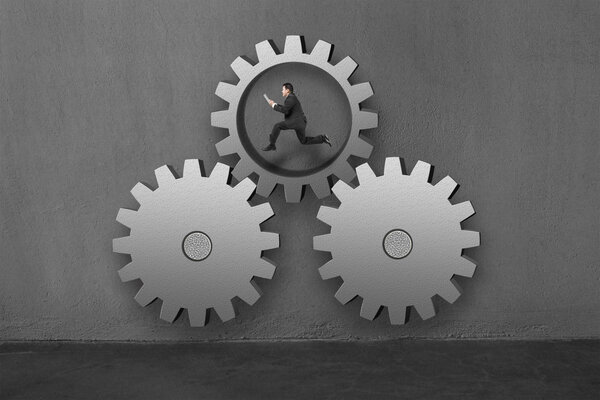 Бизнесмен работает внутри больших передач, соединяясь с другими
