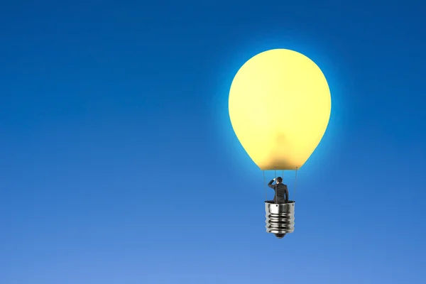Man tar glödande lampan ballong blickar i himlen — Stockfoto