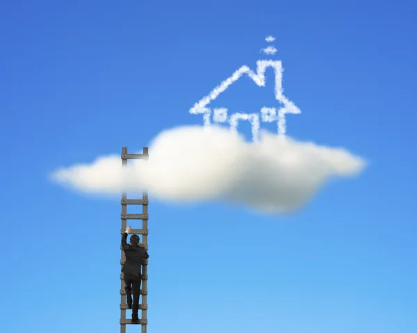 Businessman climbing on wooden ladder to reach cloud house — Stock Photo, Image