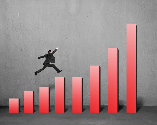 Affärsman springa och hoppa på röd stapel diagram — Stockfoto