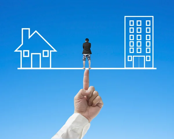 Thoughful man standing on seesaw with office and home — Stock Photo, Image