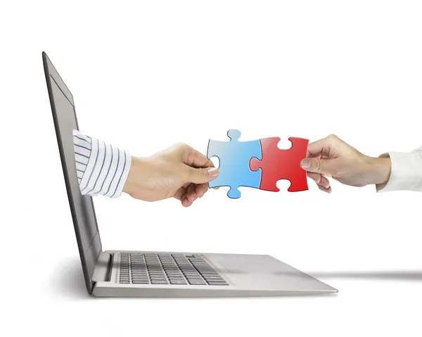 Hand holding puzzle coming out from screen connect with another — Stock Photo, Image